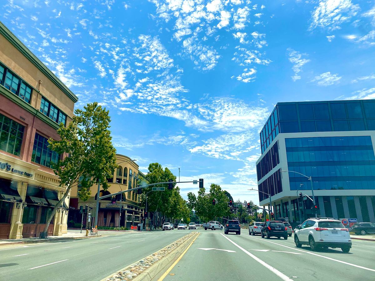 Winchester Boulevard at Olin Avenue, with Santana Row buildings on one side and a glass office tower on the other