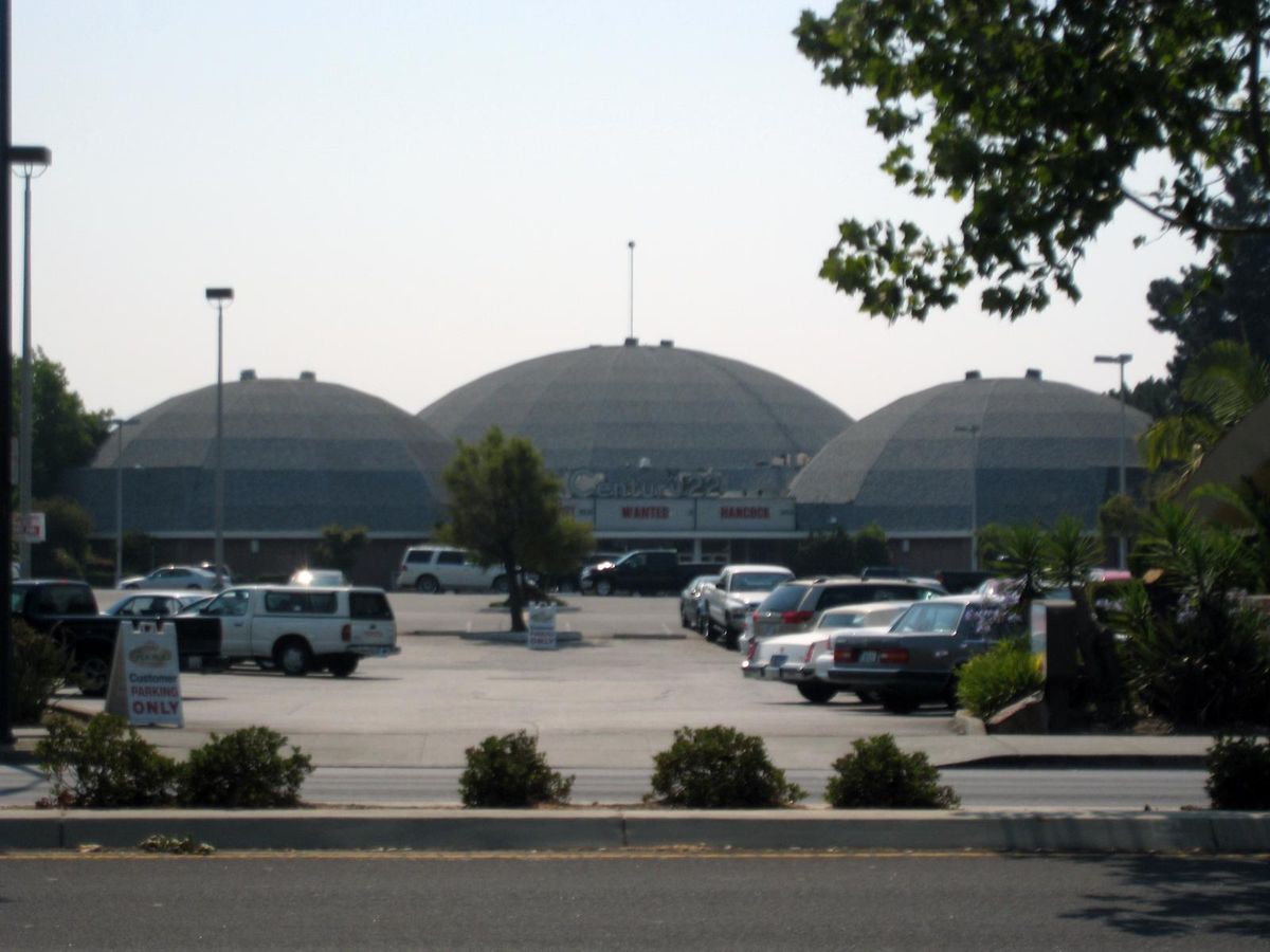 Three Century domes side by side behind a parking lot