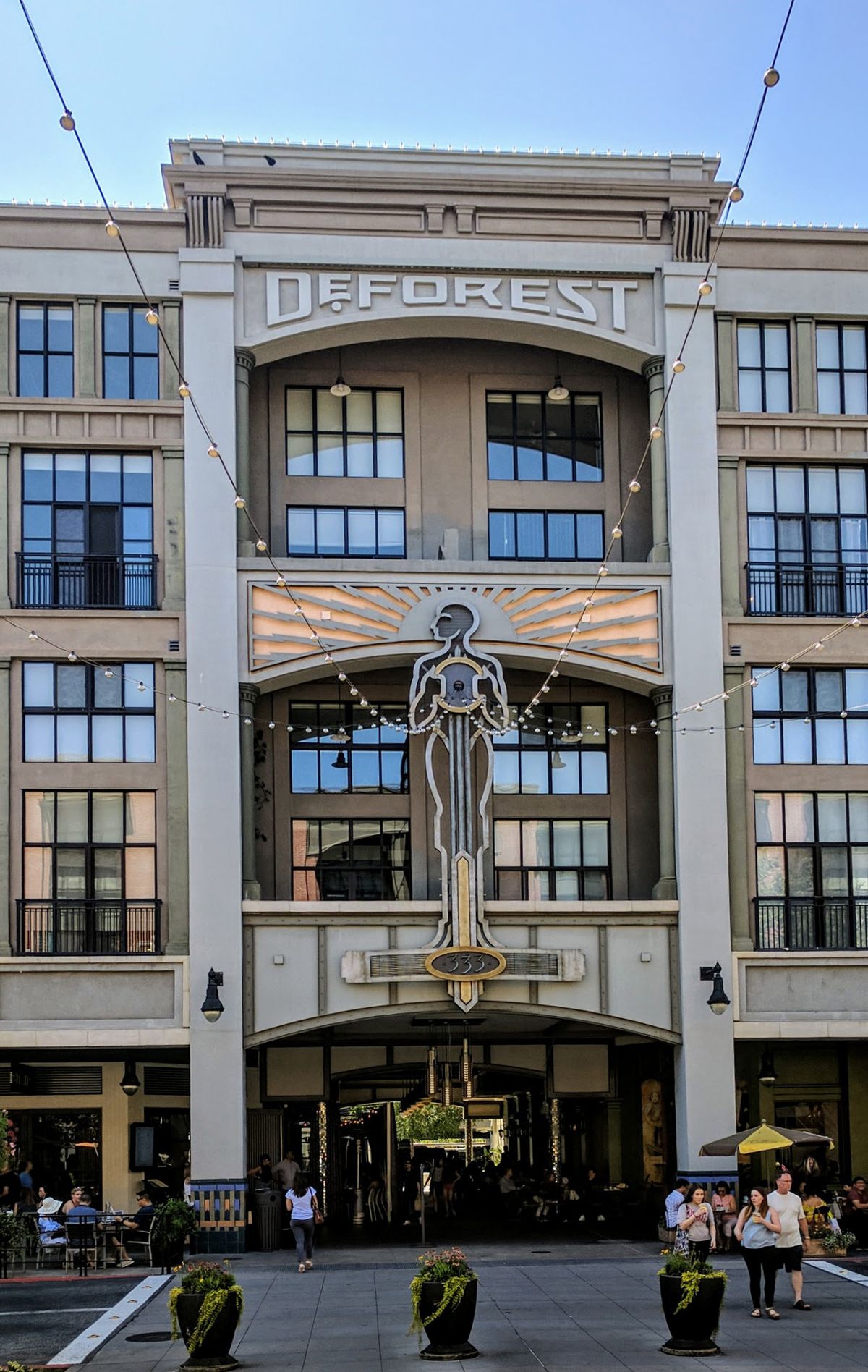 The DeForest building on Santana Row, with a tall statue set in its arched facade