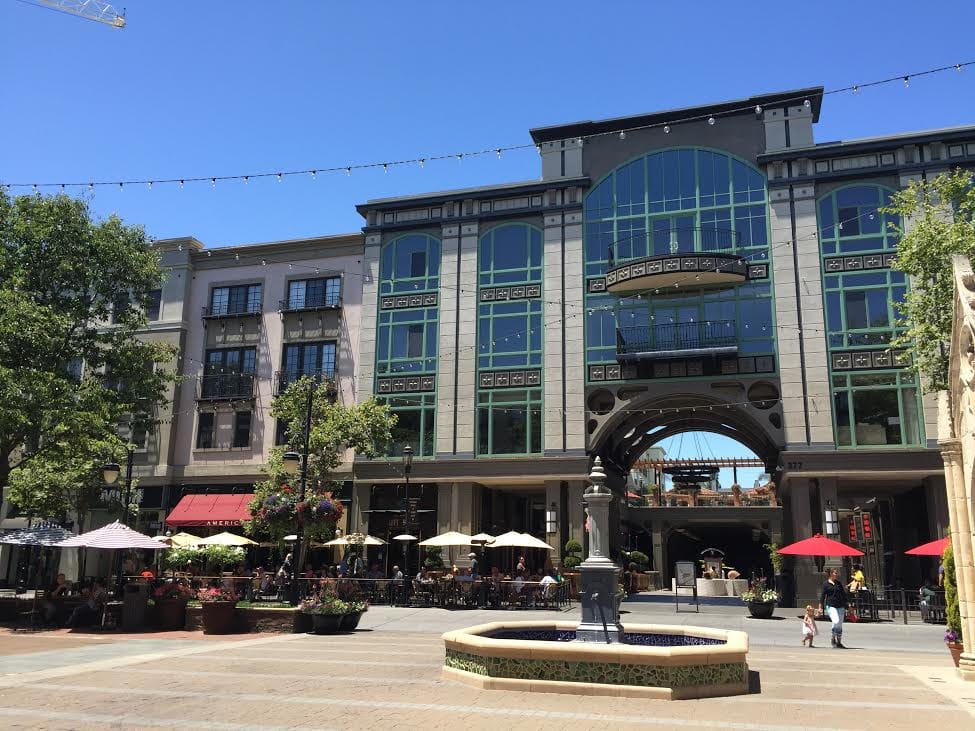 The fountain plaza on Santana Row, with cafe umbrellas and arched Mediterranean-style buildings